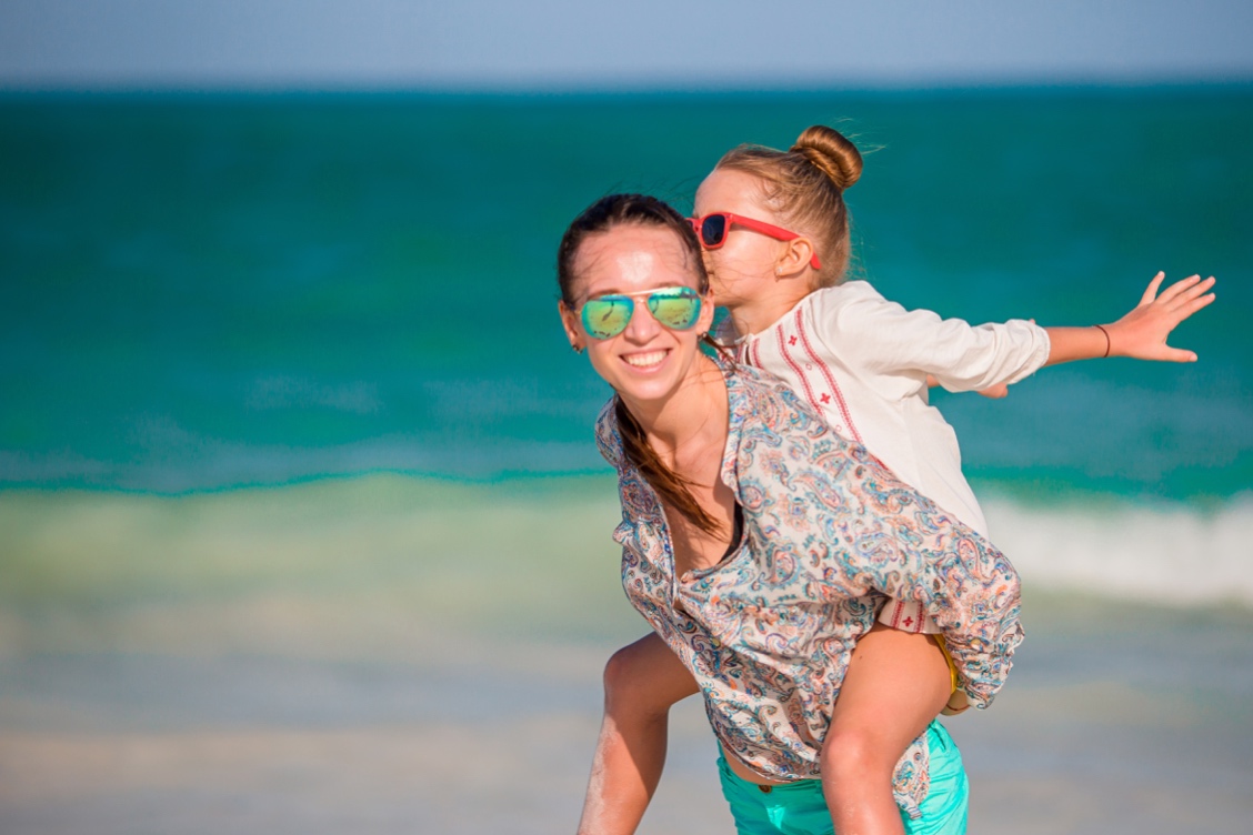 Beautiful mother and daughter at the beach enjoying summer vacation. Beautiful mother and daughter at the beach enjoying summer vacation.